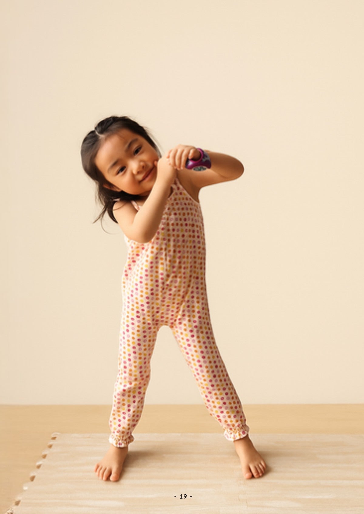 Girl wearing an Ola! Otter organic cotton smocked jumpsuit