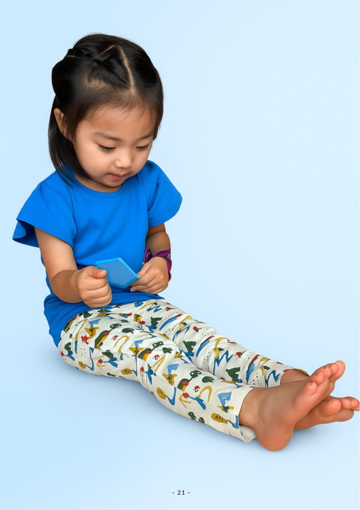 Girl sitting in Ola! Otter organic cotton printed leggings