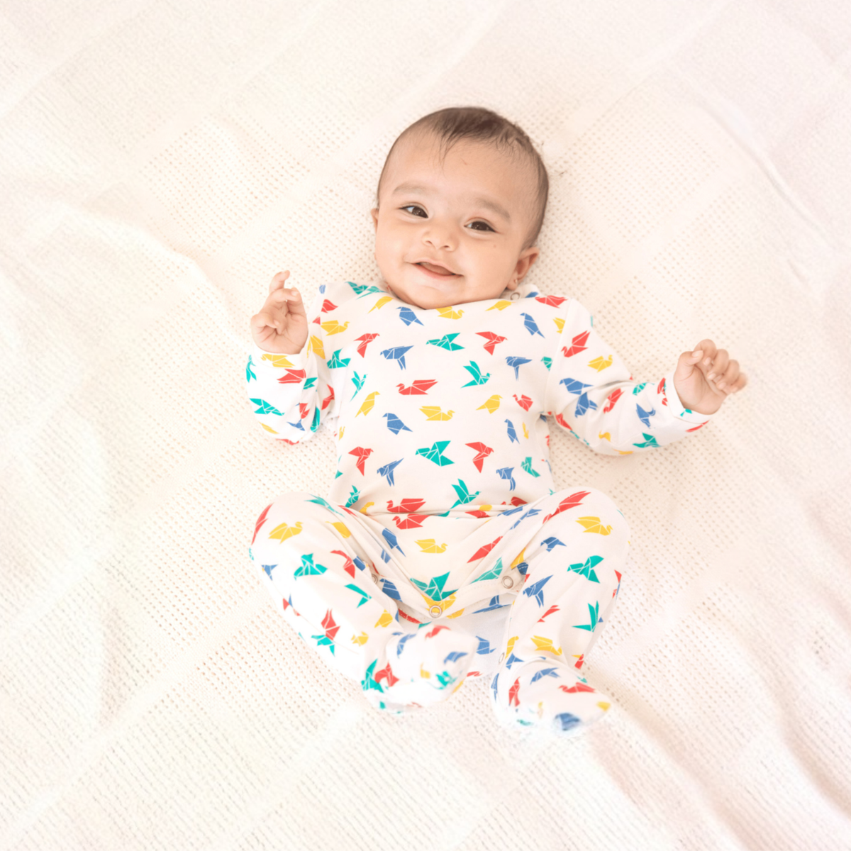 Smiling baby in an Ola! Otter organic cotton sleepsuit