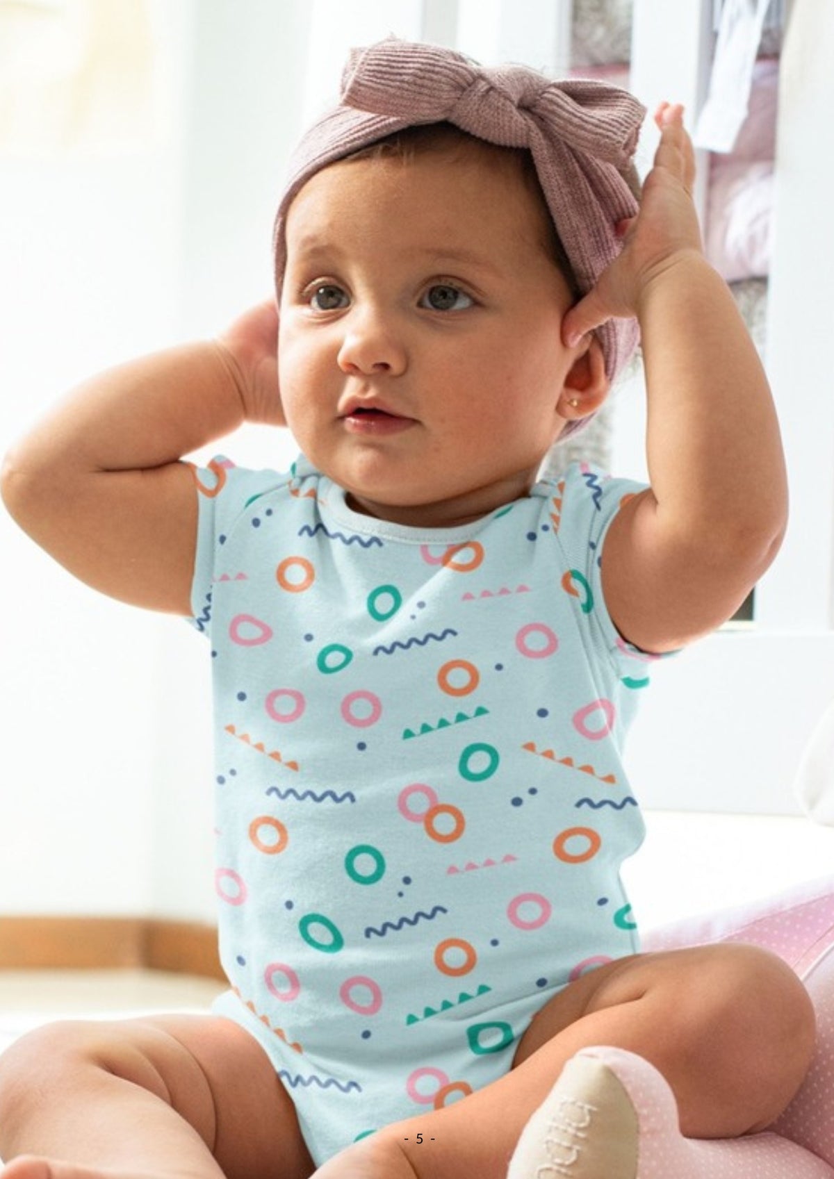 Baby girl in an Ola! Otter printed organic cotton bodysuit
