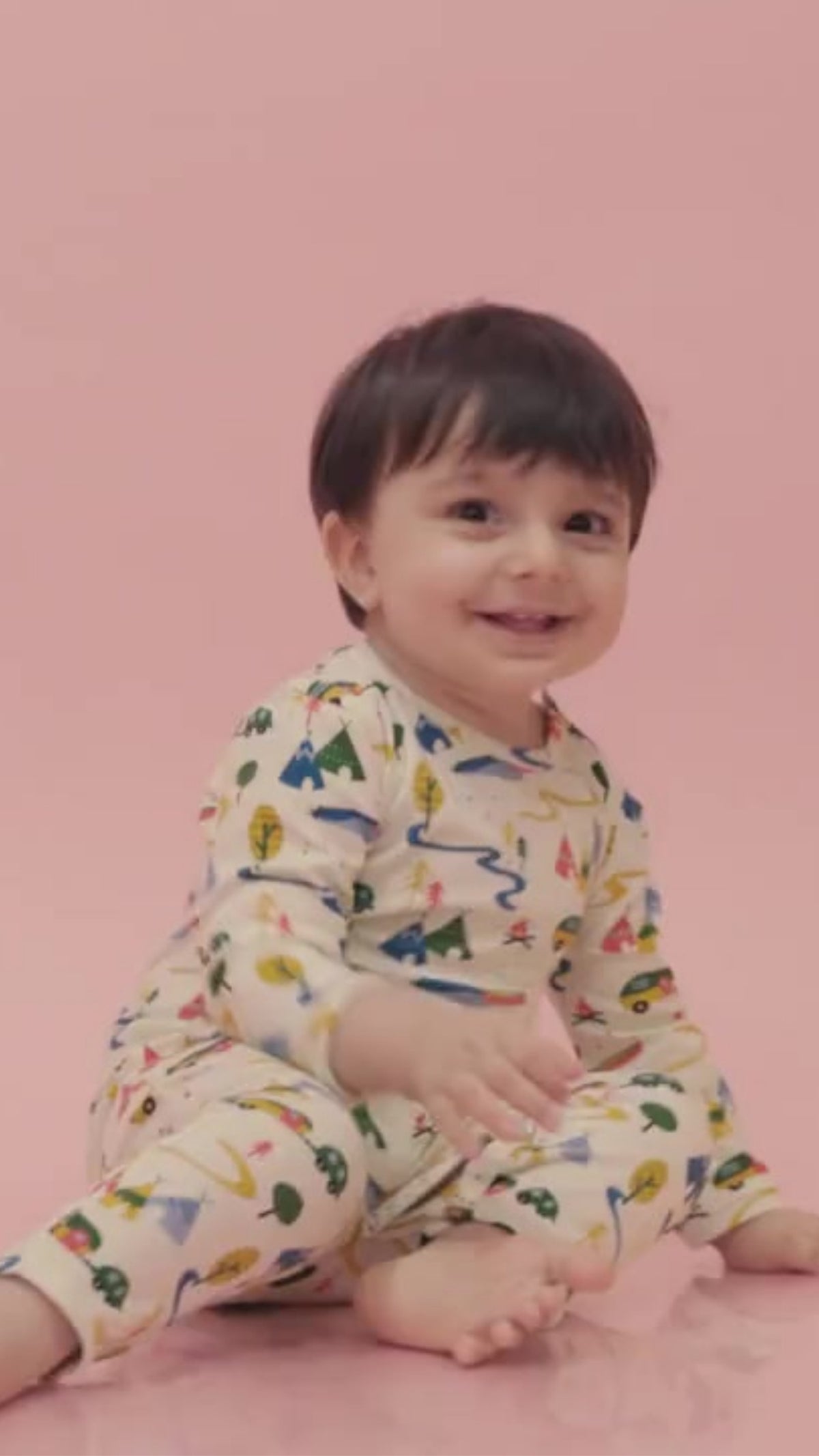 Smiling baby in an Ola! Otter organic cotton sleepsuit